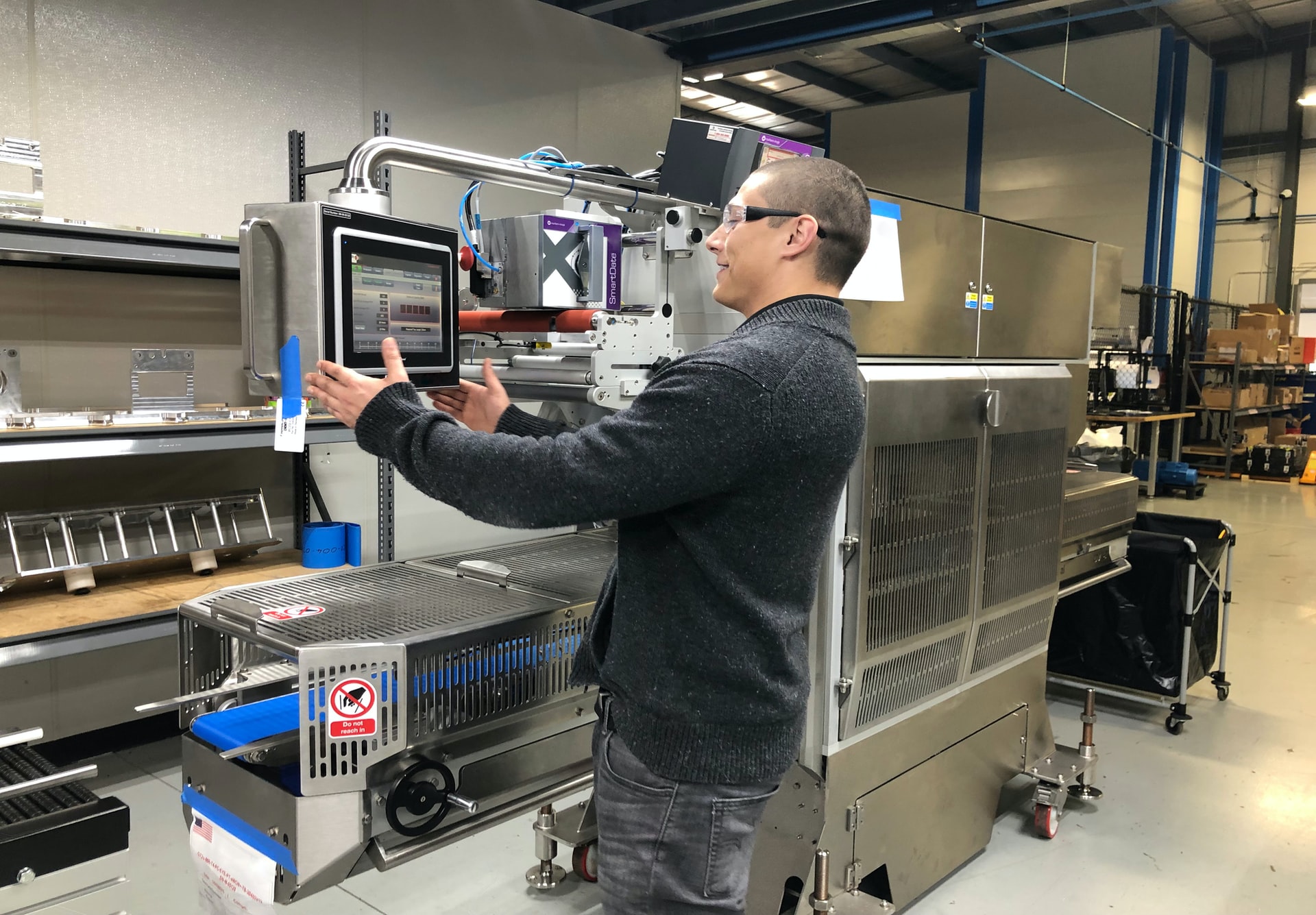 Dans une usine, un homme effectue un réglage sur l'écran d'une machine