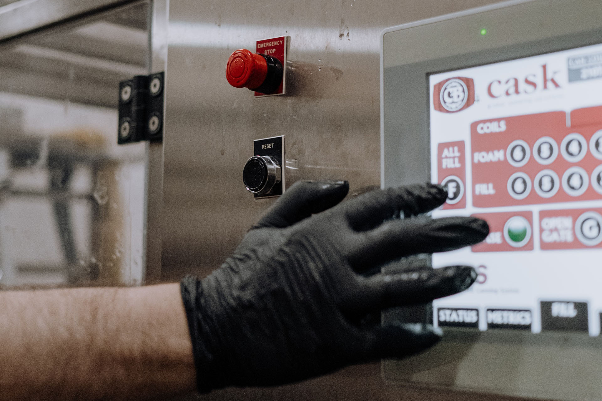 Main gantée d'une personne sur une machine industrielle