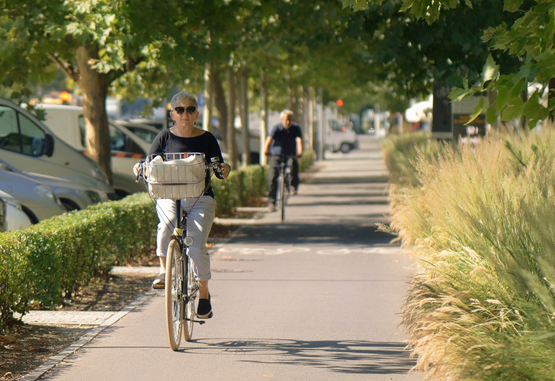 Femme aux cheveux blancs faisant du vélo sur une piste cyclable