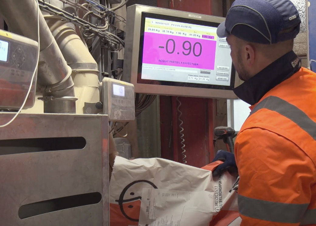 Homme portant un casque de sécurité utilisant une balance industrielle