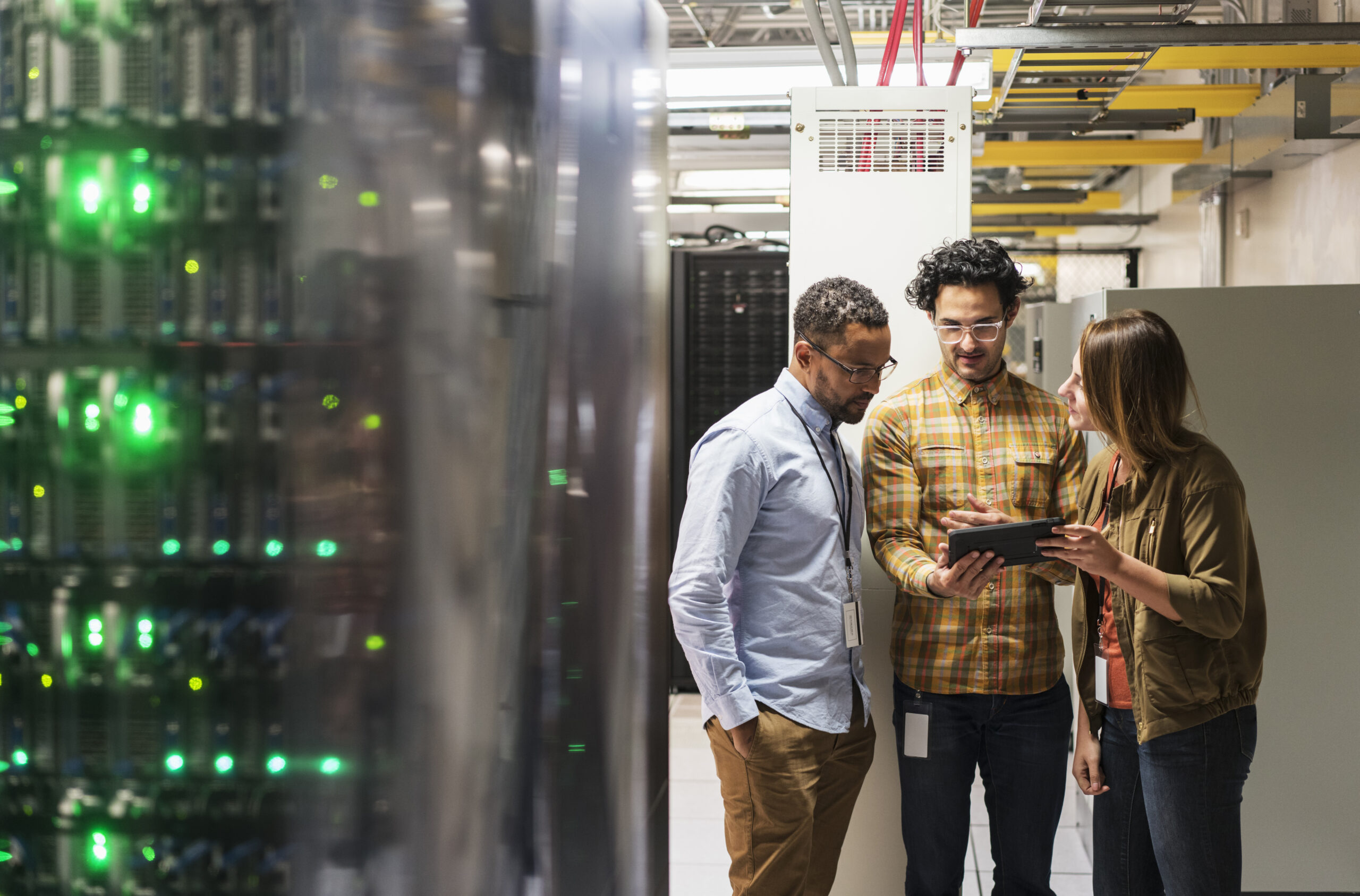 Trois personne près d'un serveur informatique