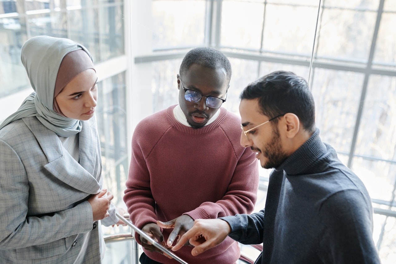 Trois personnes autour d'une tablette parlent