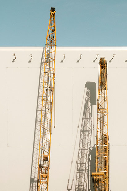 Deux grues jaune contre le mur d'un bâtiment