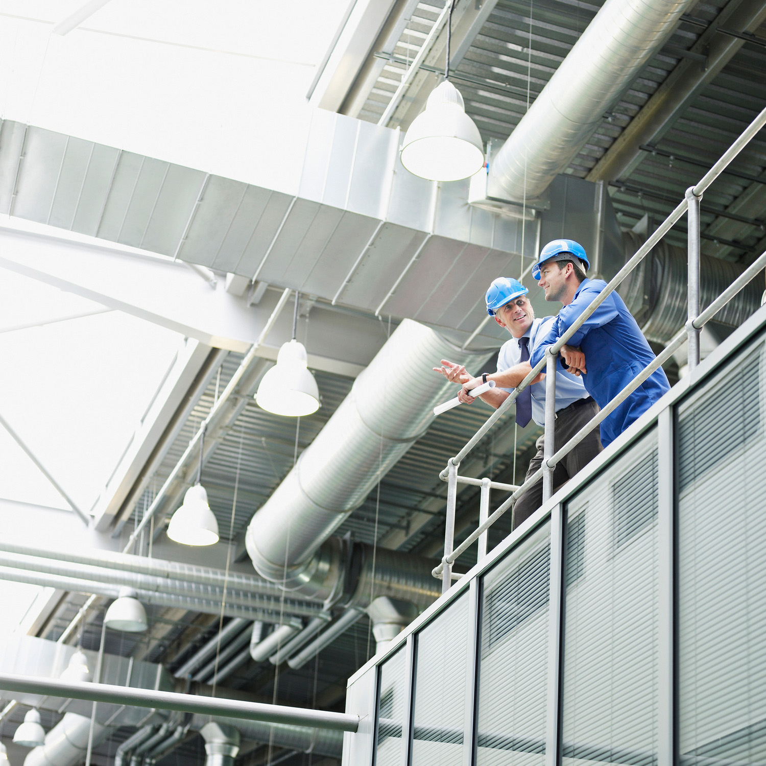 Deux hommes blancs portant un casque dans une usine
