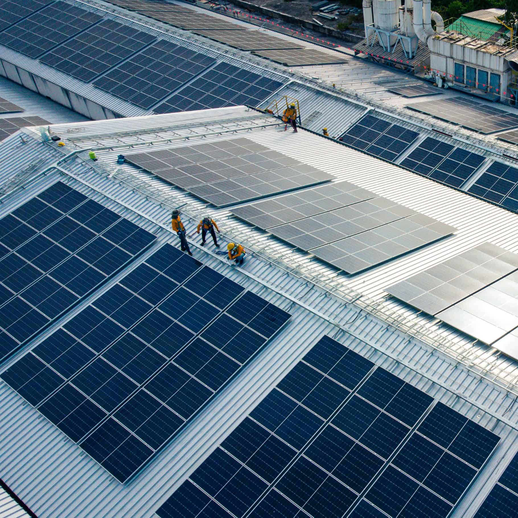Toits de bâtiments en métal en pente sur lequels sont installés des panneaux photovoltaïques