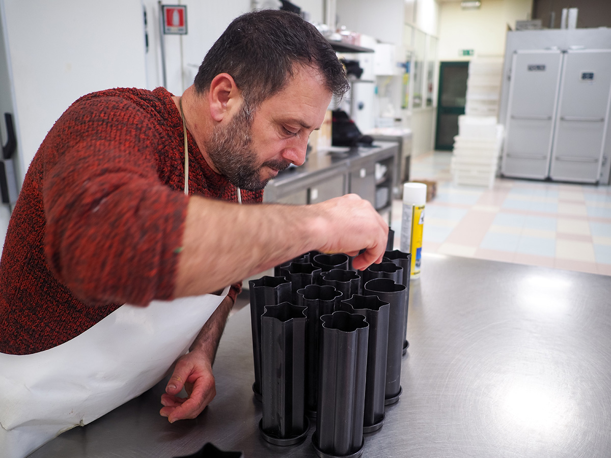 Uomo in una cucina professionale preparando stampi