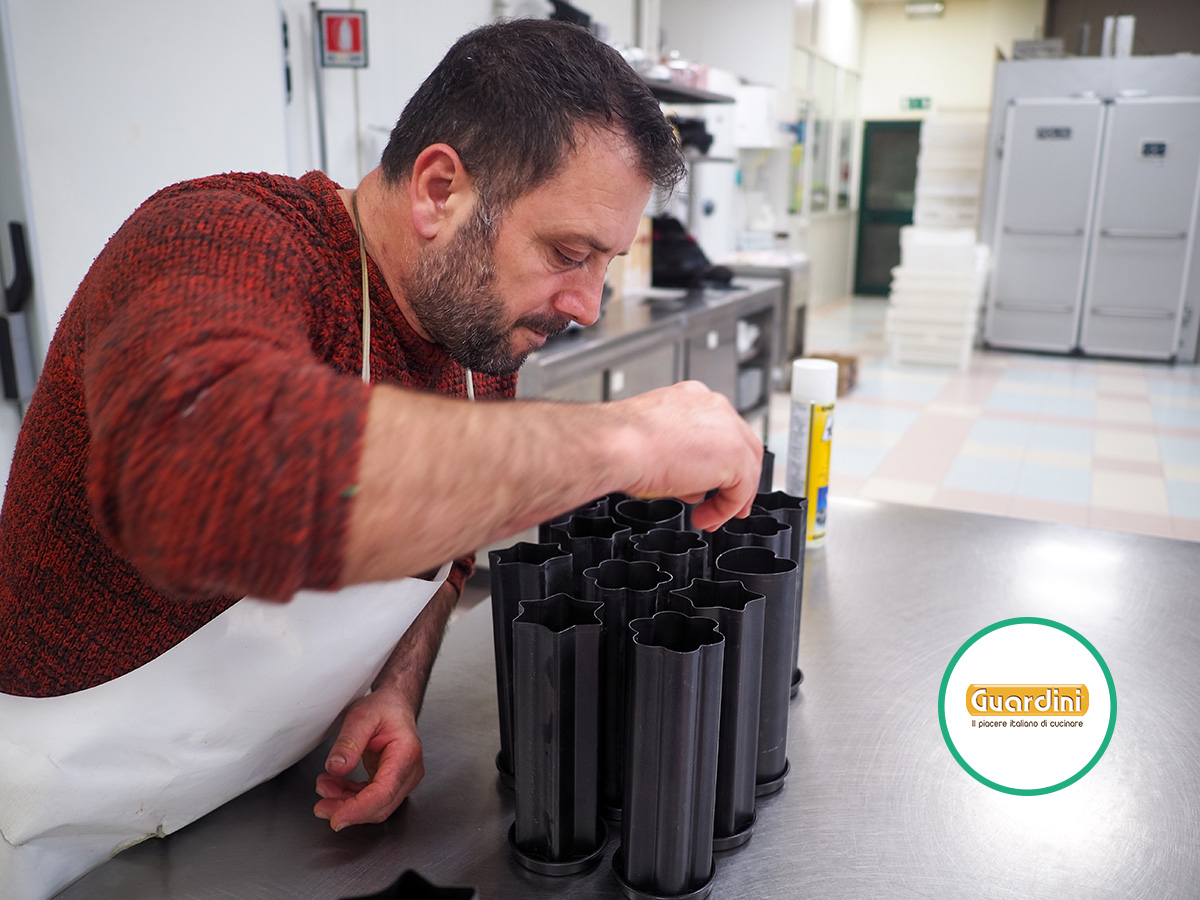 Uomo in una cucina professionale preparando stampi