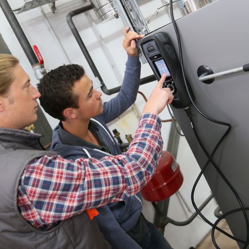 Deux hommes devant une pompe à chaleur