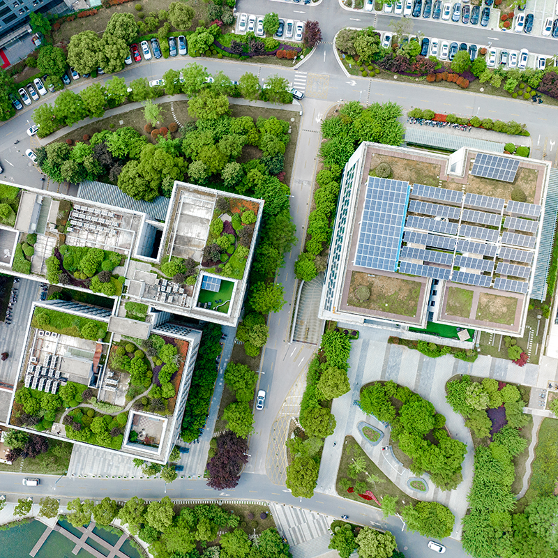 Vue aérienne d'immeubles d'habitation avec des panneaux solaires sur le toit et entourés d'arbres